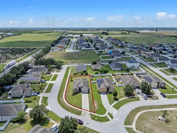 an aerial view of residential houses with outdoor space and ocean view