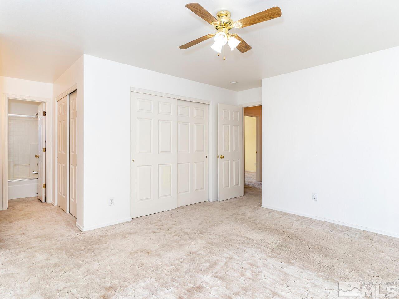 4765 Goodwin Road Sparks, NV 89436 - Photo 14 of 22 an empty room with a chandelier fan and closet