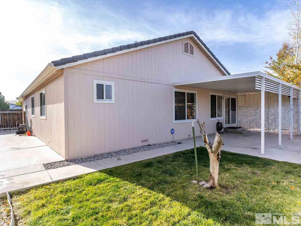 4765 Goodwin Road Sparks, NV 89436 - Photo 22 of 22 a backyard of a house with table chairs and wooden fence