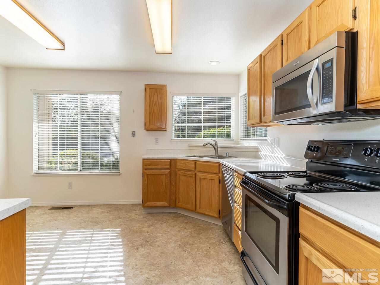 4765 Goodwin Road Sparks, NV 89436 - Photo 10 of 22 a kitchen with stainless steel appliances granite countertop a stove a sink and a microwave
