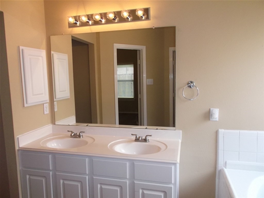 1835 Manor Drive Baytown, TX 77521 - Photo 9 of 16 a bathroom with a double vanity sink and a mirror