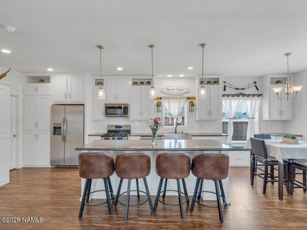 147 Pinecrest Trail Williams, AZ 86046 - Photo 11 of 39 a kitchen with stainless steel appliances kitchen island granite countertop a dining table chairs and white cabinets