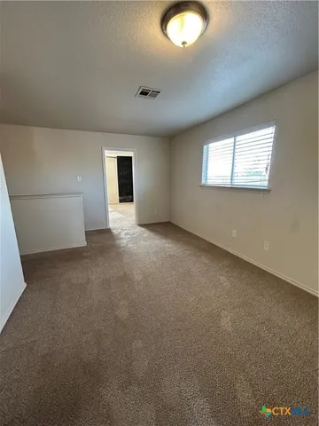 en empty room with windows and ceiling fan