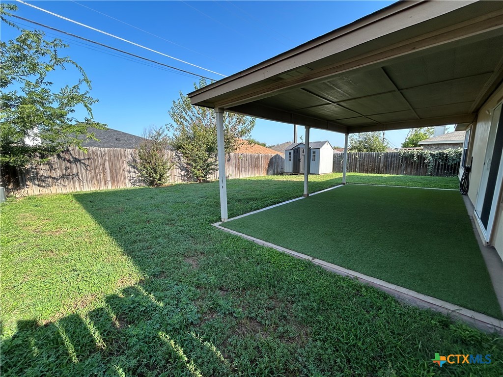 3043 Rain Dance Loop Harker Heights, TX 76548 - Photo 19 of 20 a backyard of a house with table and chairs under an umbrella