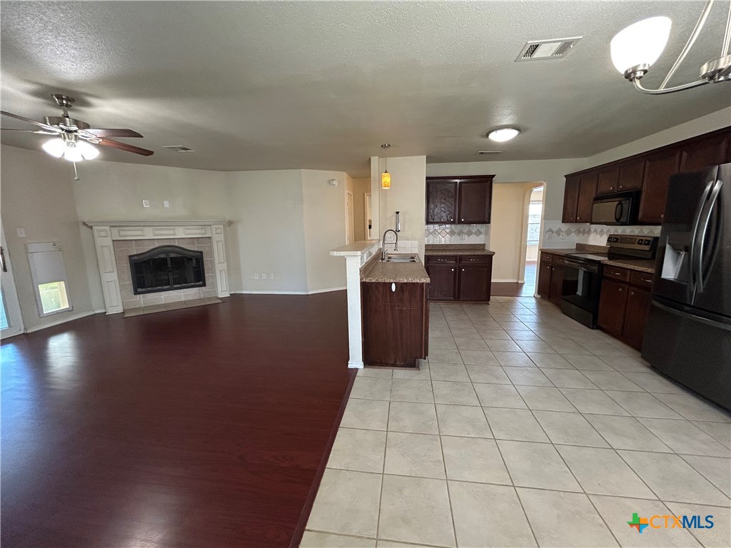 3043 Rain Dance Loop Harker Heights, TX 76548 - Photo 5 of 20 a living room with stainless steel appliances furniture a fireplace and a open kitchen view