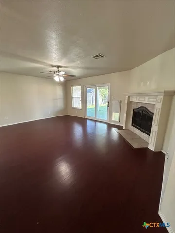 an empty room with windows and fireplace