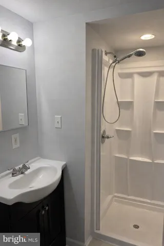 a bathroom with a sink mirror and a shower