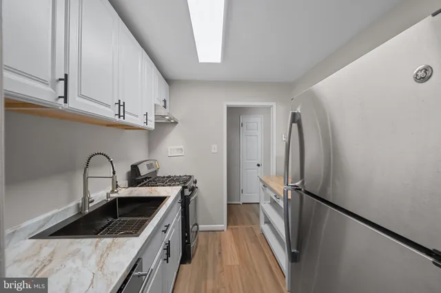 a kitchen with stainless steel appliances granite countertop a stove a refrigerator and a cabinets