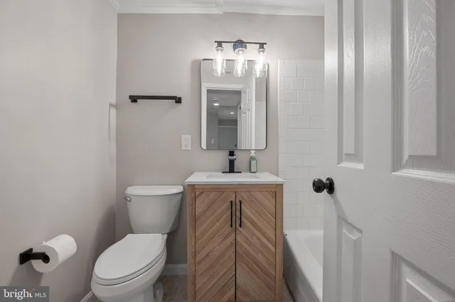 a bathroom with a toilet a sink and mirror