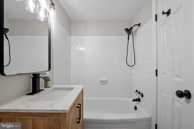a bathroom with a granite countertop sink a toilet and shower
