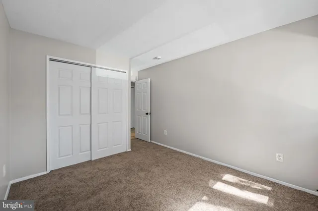 a view of a hallway with wooden floor and a bathroom