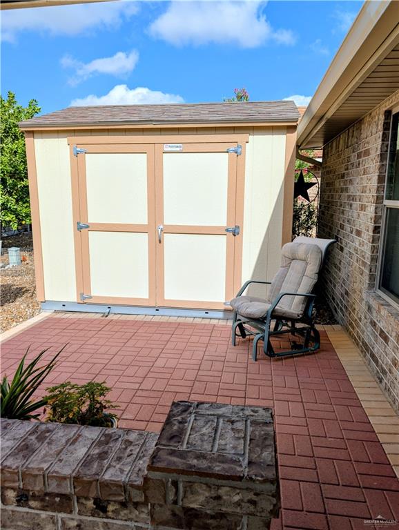 404 Jupiter Street Mission, TX 78572 - Photo 21 of 22 View of patio featuring a storage shed with tie-downs and retractable ramp.