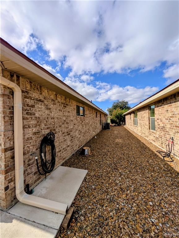 404 Jupiter Street Mission, TX 78572 - Photo 22 of 22 View of side of home featuring brick siding and recessed lighting.