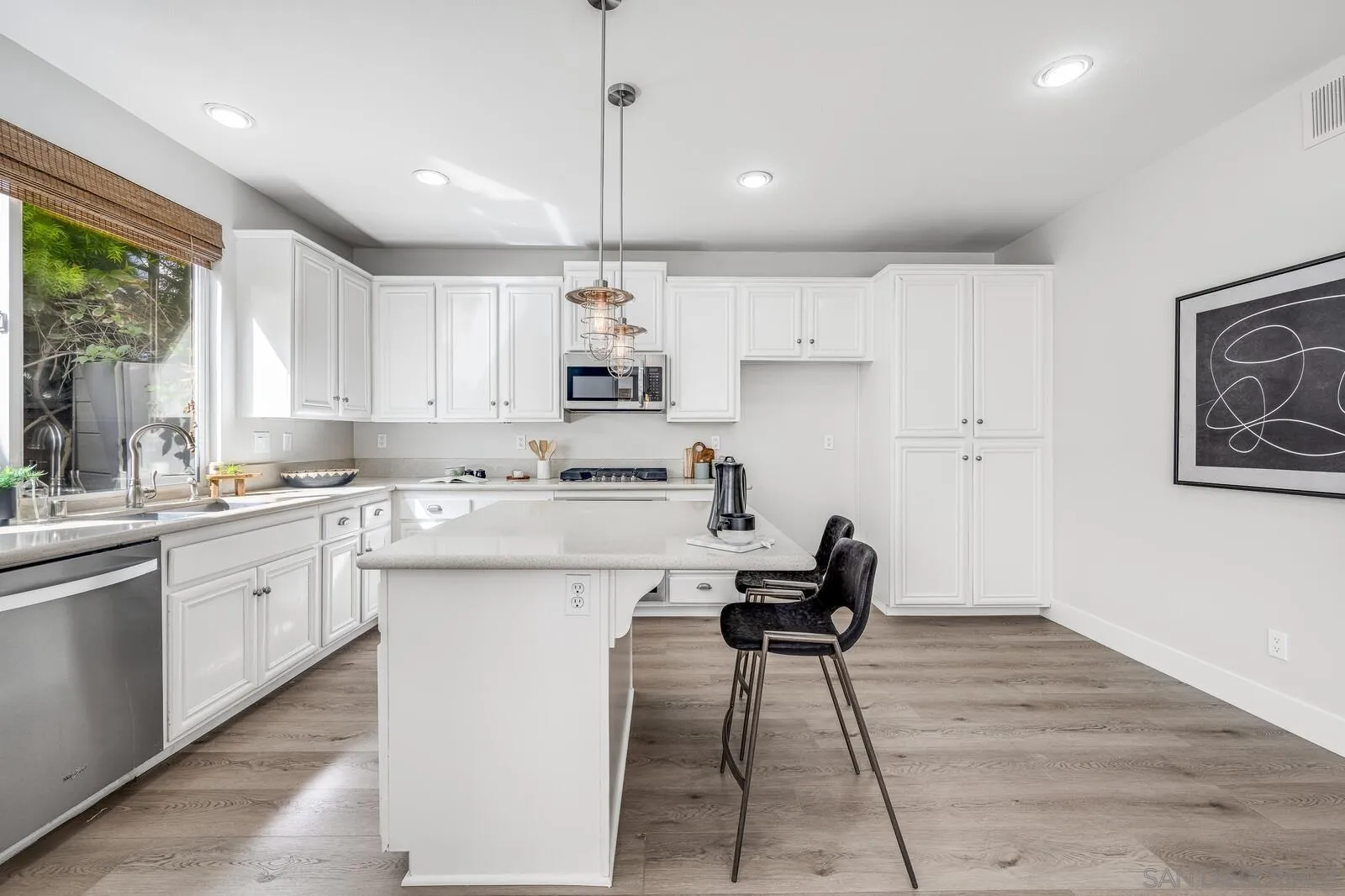 535 Anchorage Avenue Carlsbad, CA 92011 - Photo 11 of 36 a kitchen with kitchen island a stove a sink a refrigerator and white cabinets with wooden floor