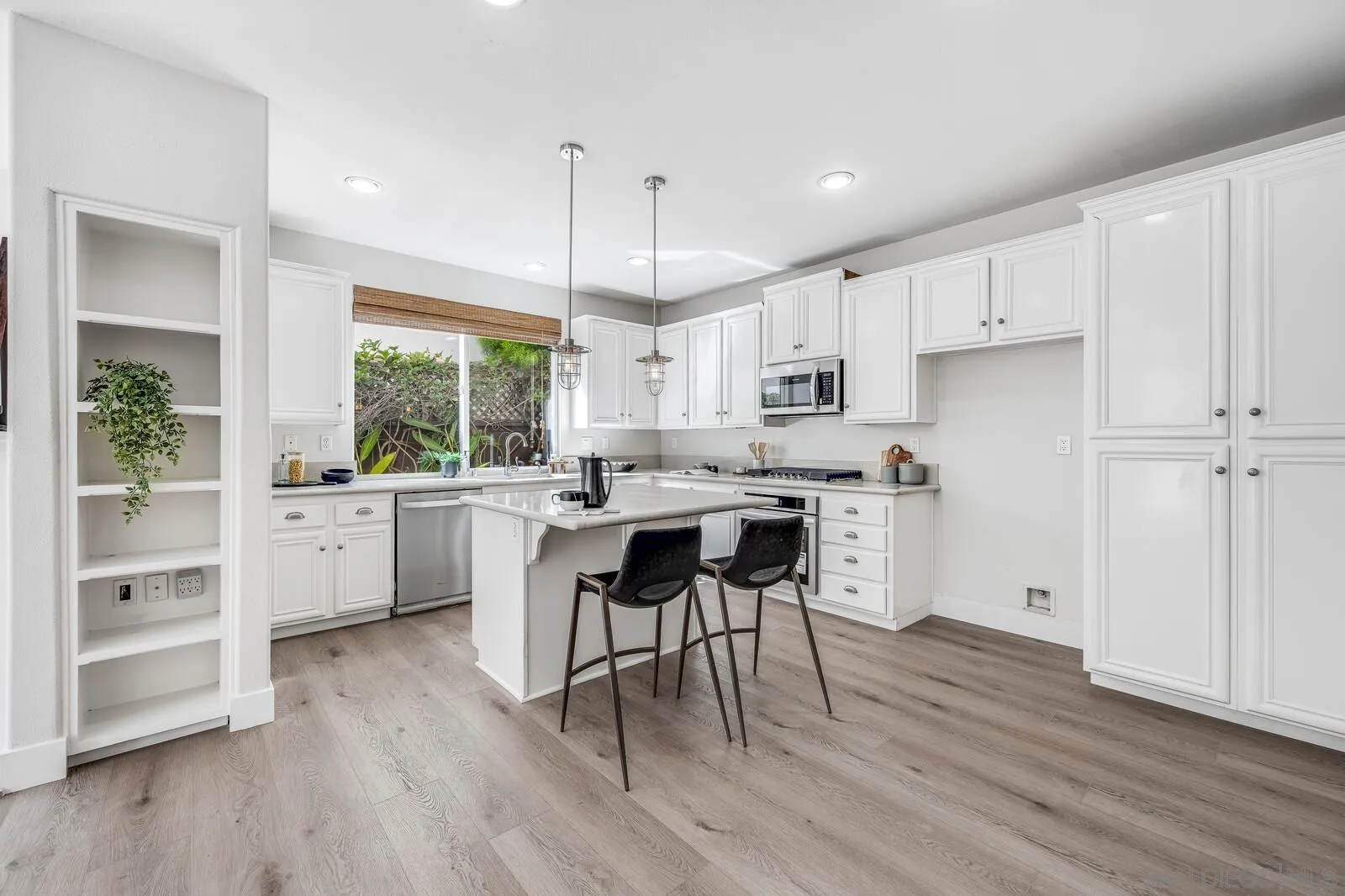 535 Anchorage Avenue Carlsbad, CA 92011 - Photo 12 of 36 a kitchen with stainless steel appliances a white table chairs and a window