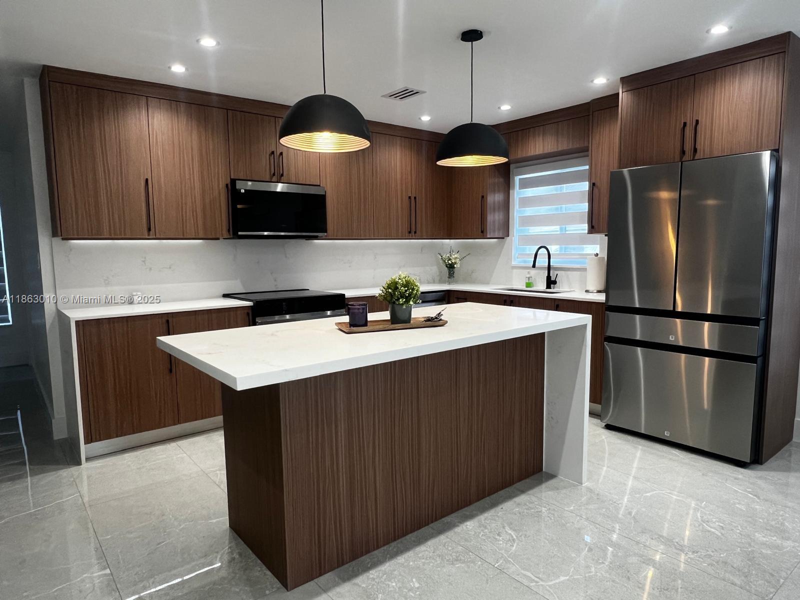 1590 Southwest 139th Avenue Davie, FL 33325 - Photo 2 of 20 a kitchen with stainless steel appliances a sink a stove a refrigerator and island