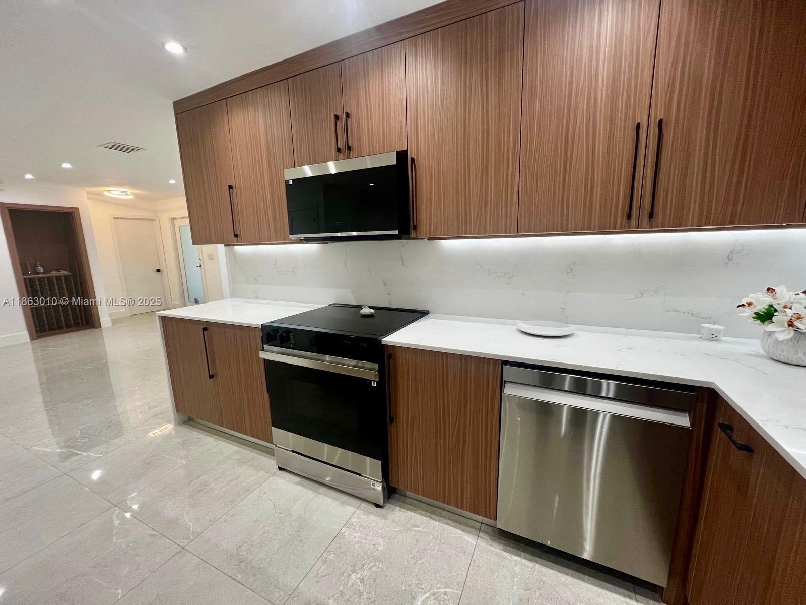 1590 Southwest 139th Avenue Davie, FL 33325 - Photo 3 of 20 a kitchen with stainless steel appliances a stove a microwave and a sink