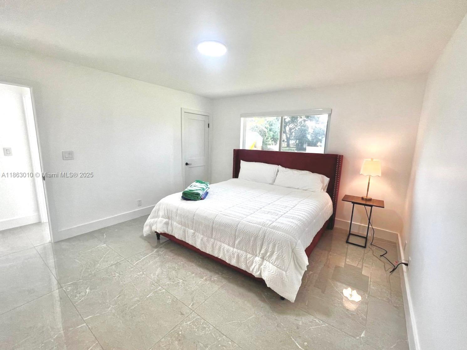 1590 Southwest 139th Avenue Davie, FL 33325 - Photo 8 of 20 a bedroom with a bed and a window