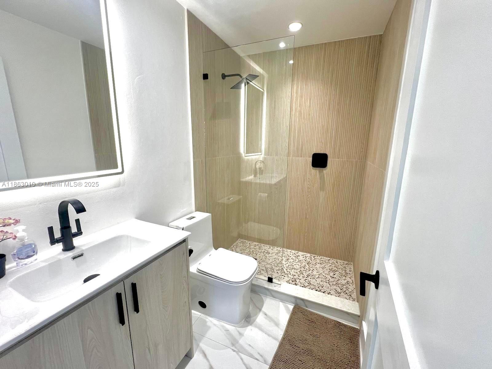 1590 Southwest 139th Avenue Davie, FL 33325 - Photo 10 of 20 a bathroom with a sink a toilet a mirror and shower
