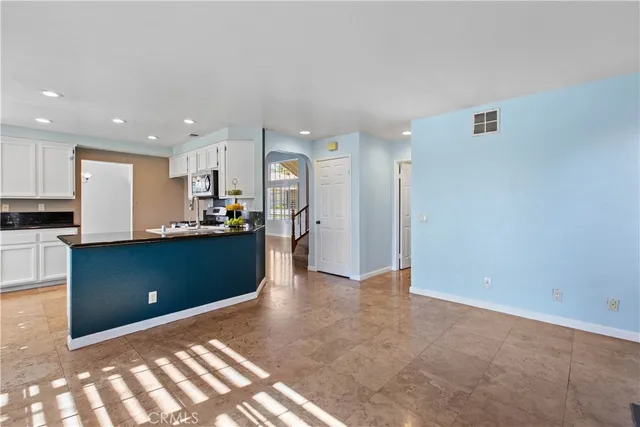 a view of a kitchen with a stove wooden cabinets and a refrigerator