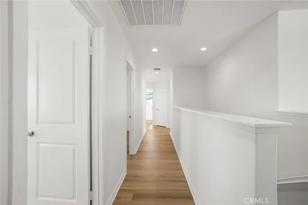 a view of a hallway with wooden floor and stairs