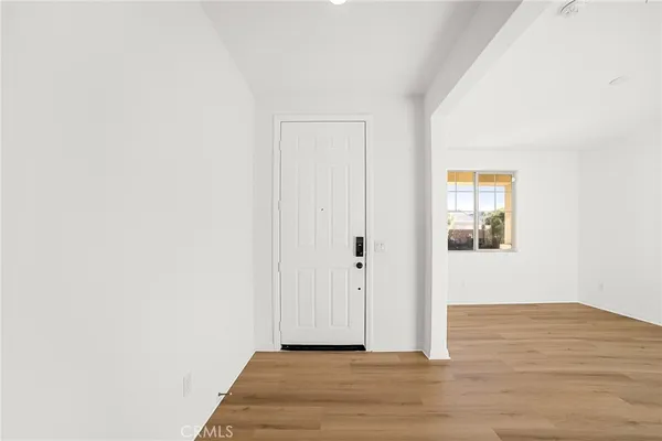 a view of a hallway with wooden floor and closet