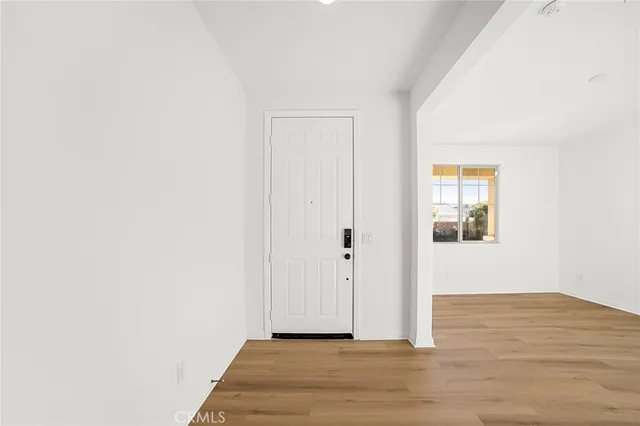 a view of a hallway with wooden floor and closet