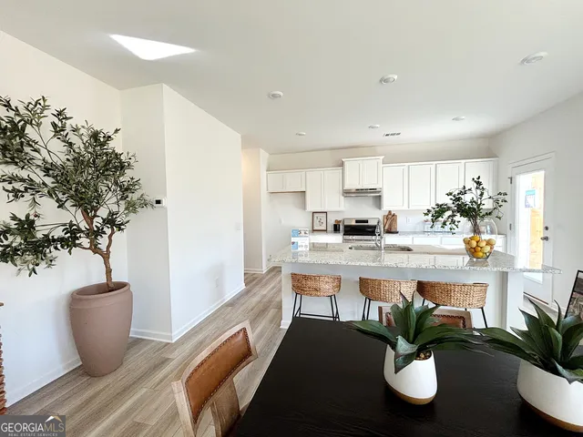 a kitchen with stainless steel appliances granite countertop a sink stove and cabinets
