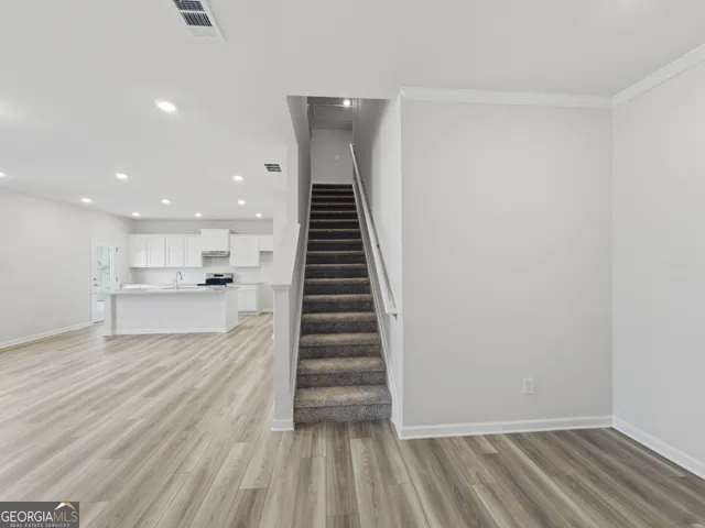 a view of a kitchen with wooden floor and windows