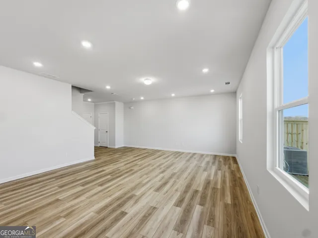 a kitchen with granite countertop white cabinets and a stove with wooden floor