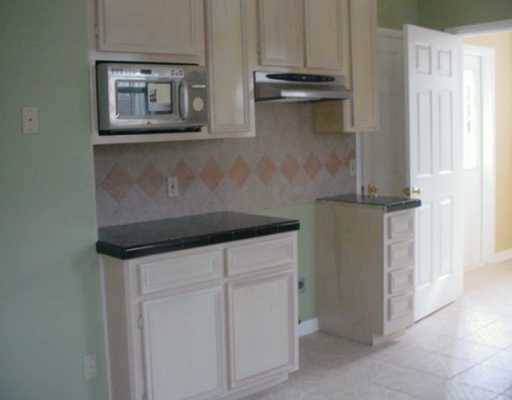 449 Southern Street Corpus Christi, TX 78404 - Photo 5 of 10 a kitchen with white cabinets and a refrigerator