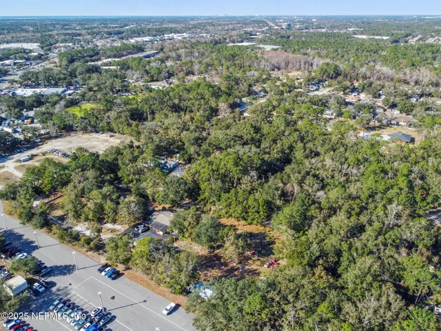 an aerial view of residential houses with outdoor space and trees