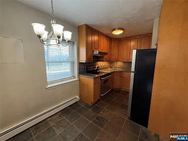 a kitchen with stainless steel appliances granite countertop a stove a refrigerator and a sink