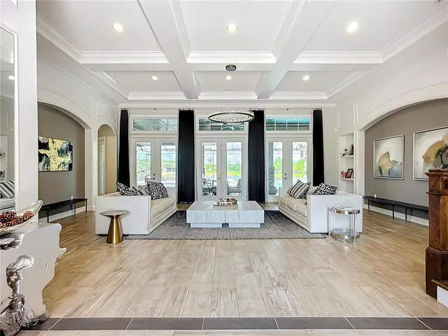 a living room with furniture large window and wooden floor