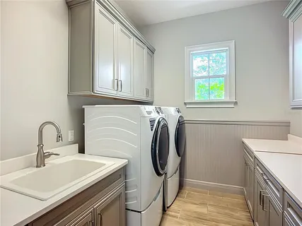 a kitchen with a stove a sink and a dining table with wooden floor
