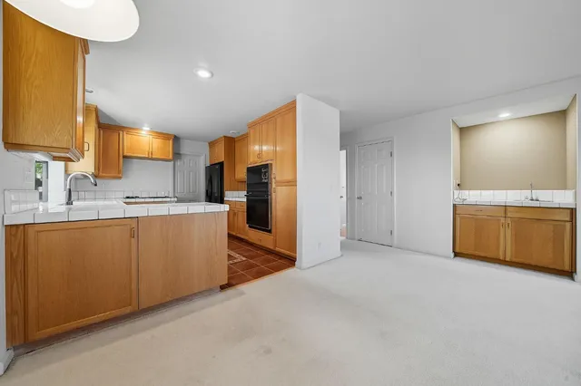 a backyard of a house with barbeque oven table and chairs
