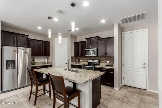 a kitchen with refrigerator and cabinets