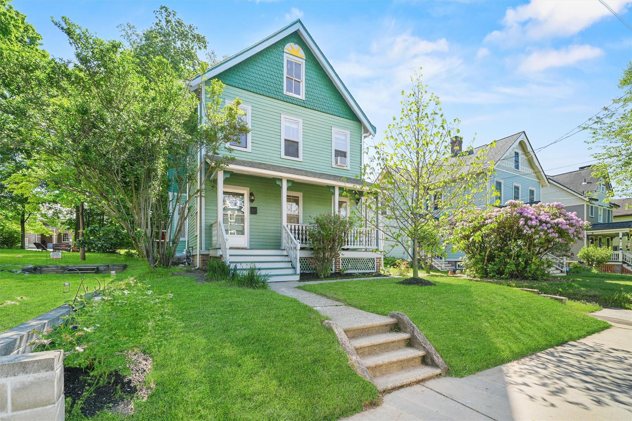 Colonial-style house with covered porch and a front yard