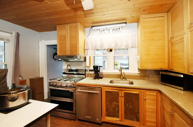 a kitchen with stainless steel appliances a stove a sink and a refrigerator