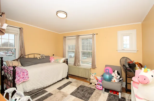 a bedroom with a bed dresser and a window