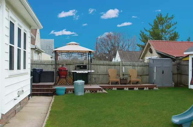 a view of a house with backyard and sitting area