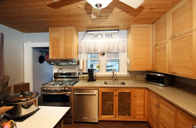 a kitchen with stainless steel appliances a sink stove and window