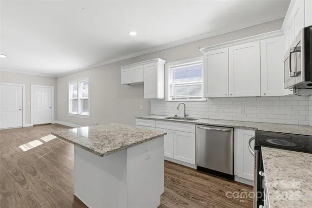 a kitchen with granite countertop a sink stove and cabinets