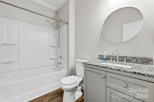 a bathroom with a granite countertop sink mirror vanity and toilet