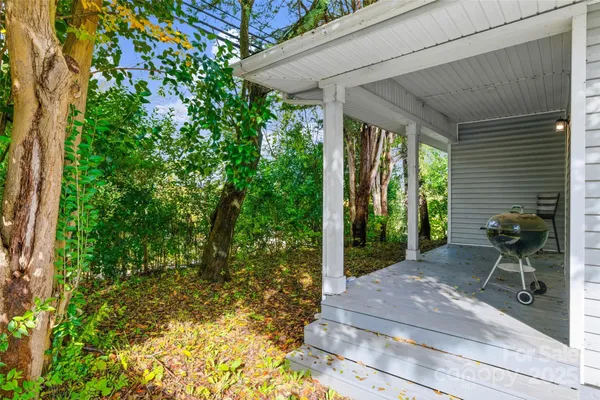 a patio with table and chairs and potted plants