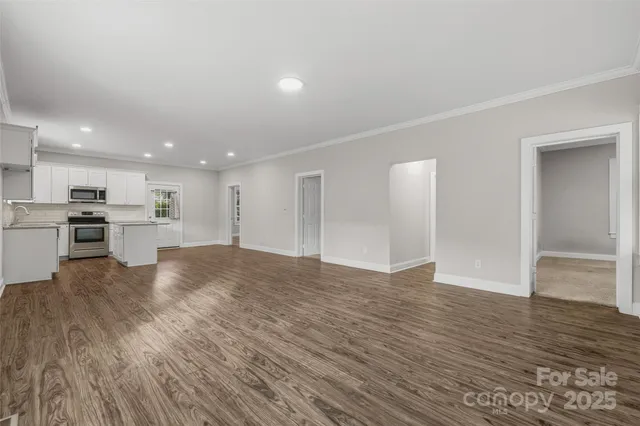 a view of kitchen with kitchen island wooden floor appliances and cabinets