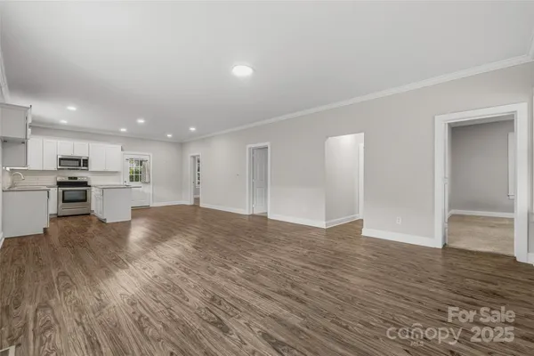 a view of kitchen with kitchen island wooden floor appliances and cabinets