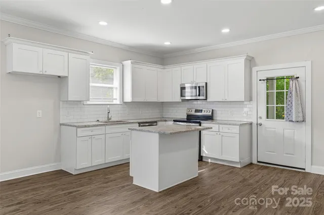 a kitchen with granite countertop white cabinets and white appliances