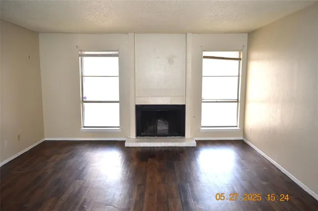 an empty room with wooden floor and a window