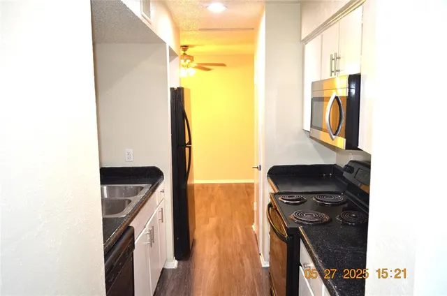 a view of a living room with a sink and wooden floor
